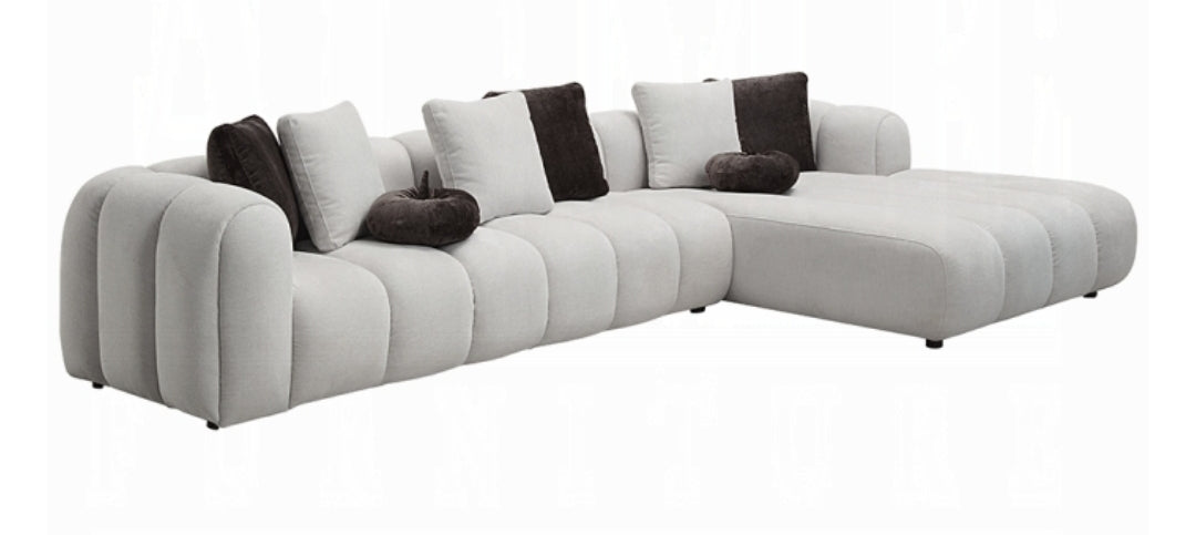 Channel tufted Right facing sectional upholstered in white fabric waccent pillows