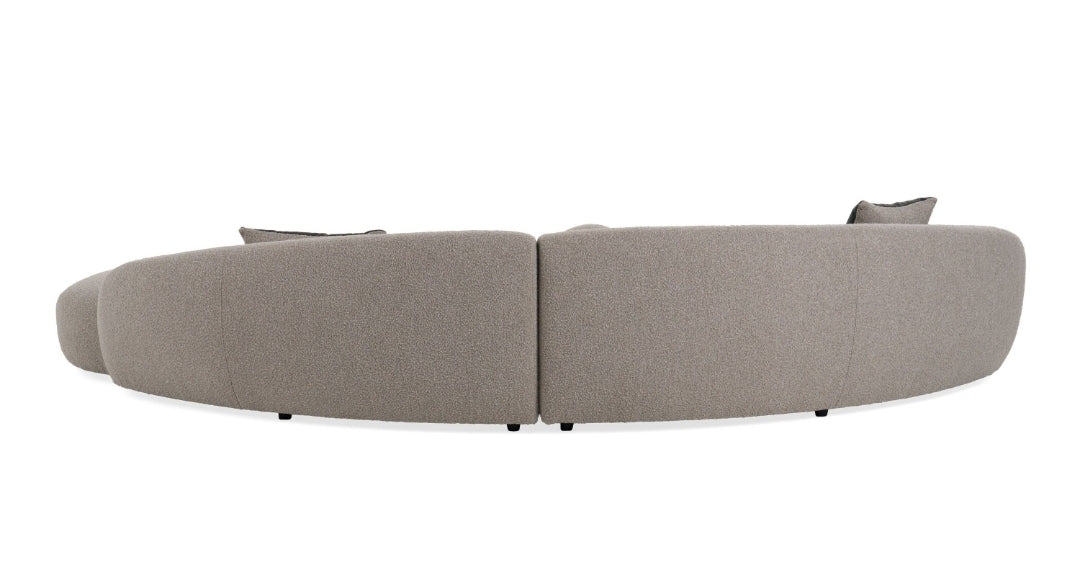 Glam Curved Sectional Sofa upholstered in taupe fabric with black and taupe accent pillows