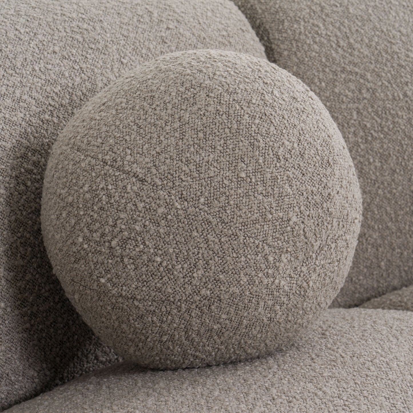 Glam Curved Sectional Sofa upholstered in taupe fabric with black and taupe accent pillows
