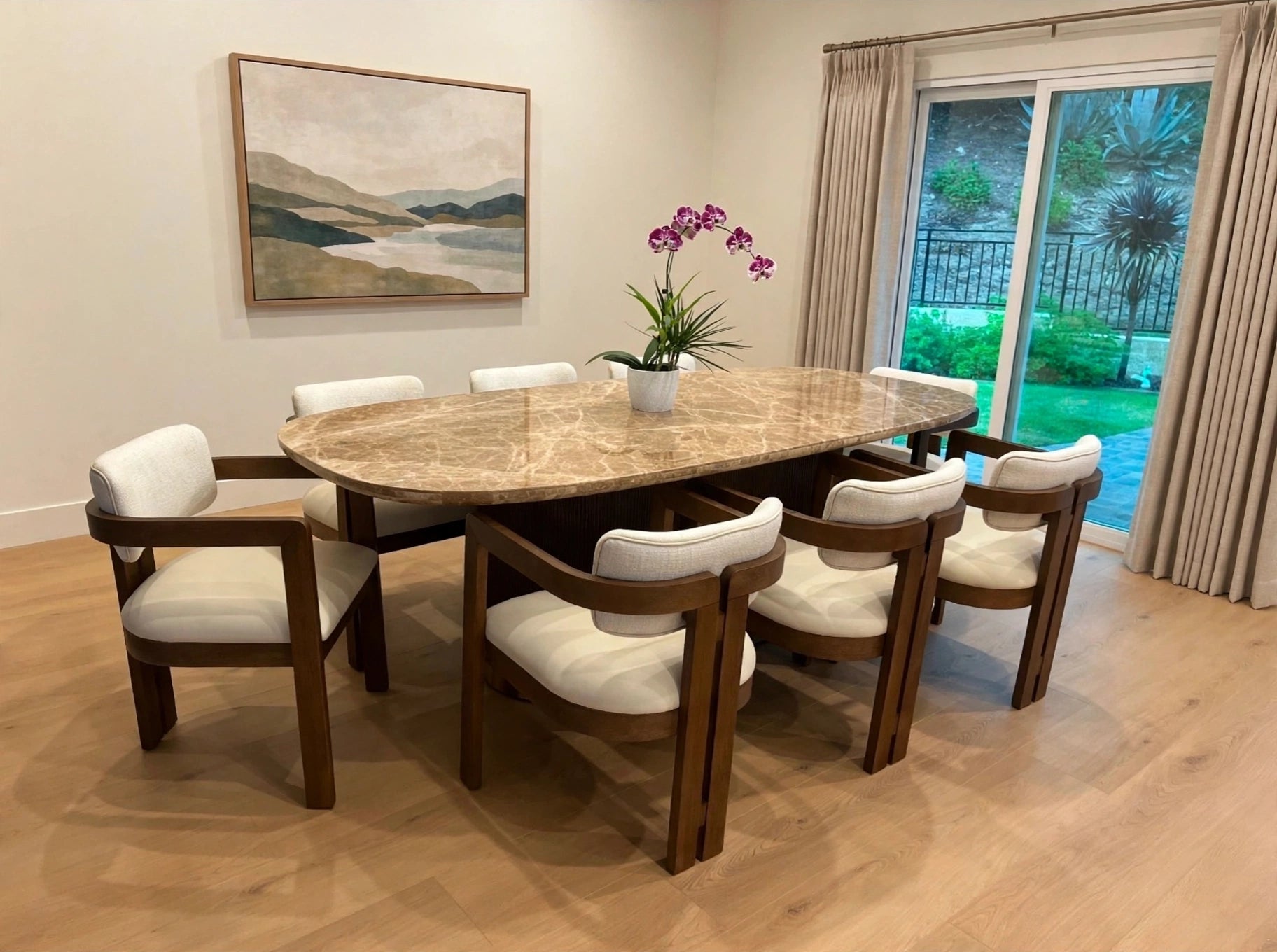 Oval marble dining table with cream and wood chairs